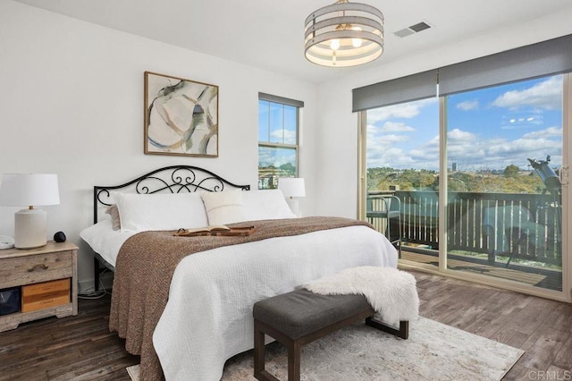 bedroom featuring access to exterior, visible vents, and wood finished floors