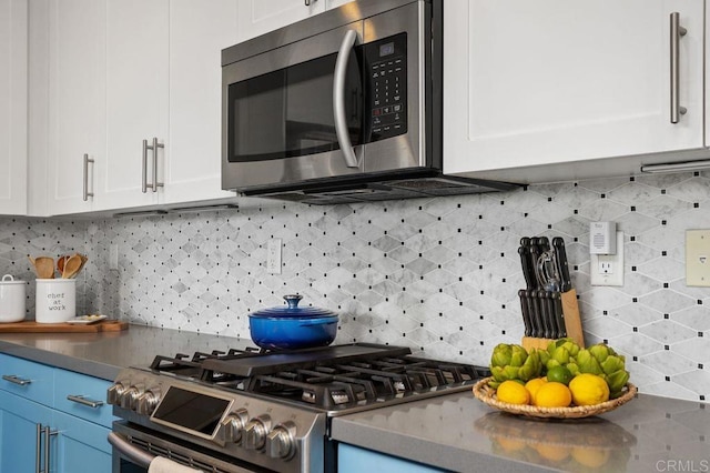 kitchen featuring appliances with stainless steel finishes, decorative backsplash, and white cabinets