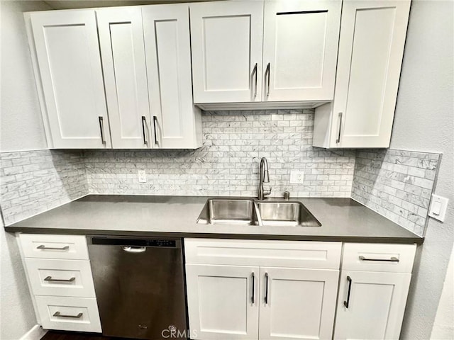 kitchen featuring a sink, dark countertops, white cabinets, decorative backsplash, and dishwasher