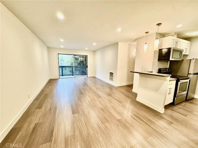 kitchen with light wood-type flooring, stainless steel appliances, baseboards, and white cabinetry