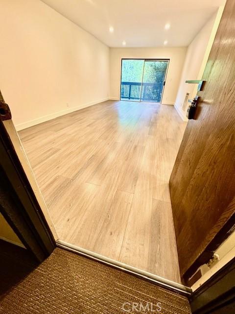 interior space with recessed lighting, wood finished floors, and baseboards