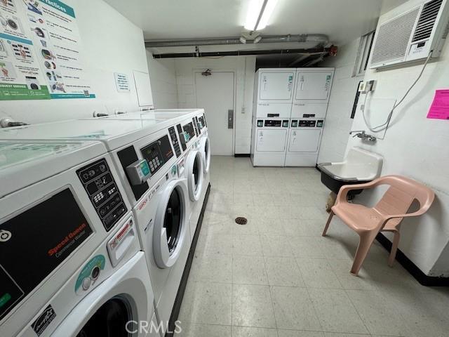 3601 W Hidden Ln Unit 309, Rolling Hills Estates, CA 90274 - shared laundry with estacked washer and dryer, independent washer and dryer, light flooring, and a wall unit AC