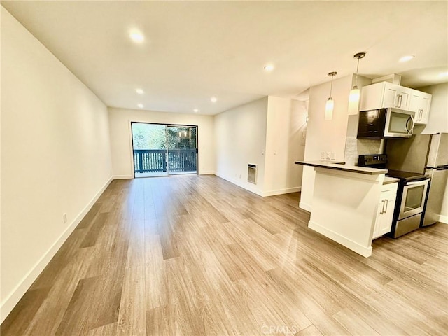 kitchen with light wood finished floors, white cabinets, appliances with stainless steel finishes, and baseboards