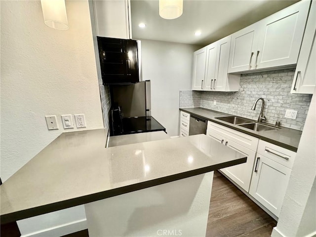 kitchen with a sink, tasteful backsplash, dark wood-style flooring, and white cabinetry