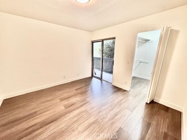 spare room featuring baseboards and wood finished floors