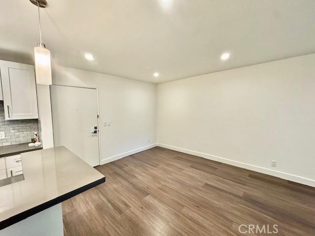 interior space featuring recessed lighting, baseboards, and dark wood-style flooring