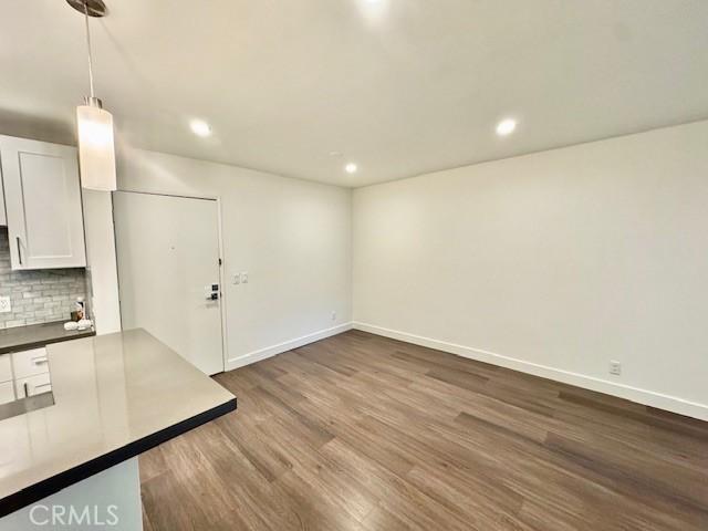 3601 W Hidden Ln Unit 309, Rolling Hills Estates, CA 90274 - unfurnished living room featuring dark wood finished floors, recessed lighting, and baseboards