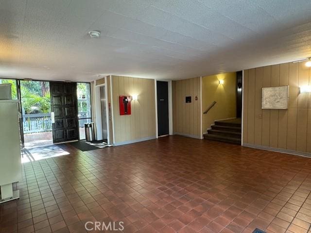3601 W Hidden Ln Unit 309, Rolling Hills Estates, CA 90274 - unfurnished living room featuring wooden walls and stairway