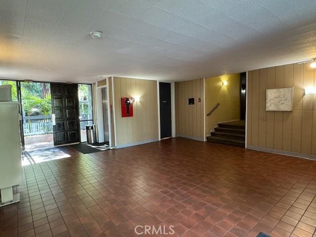 3601 W Hidden Ln Unit 309, Rolling Hills Estates, CA 90274 - unfurnished living room with wooden walls and stairs