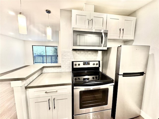 kitchen with white cabinetry, a peninsula, tasteful backsplash, and stainless steel appliances