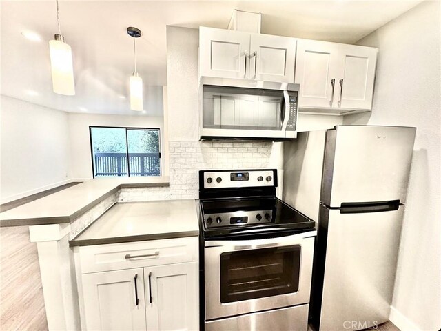 3601 W Hidden Ln Unit 309, Rolling Hills Estates, CA 90274 - kitchen featuring appliances with stainless steel finishes, white cabinetry, tasteful backsplash, and a peninsula