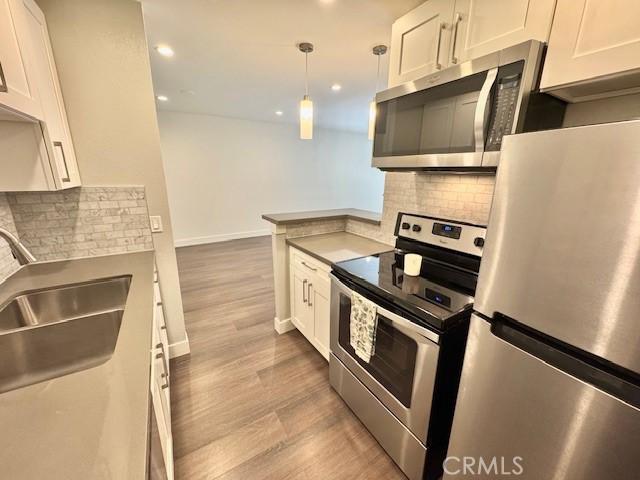 3601 W Hidden Ln Unit 309, Rolling Hills Estates, CA 90274 - kitchen with appliances with stainless steel finishes, white cabinets, a sink, tasteful backsplash, and recessed lighting