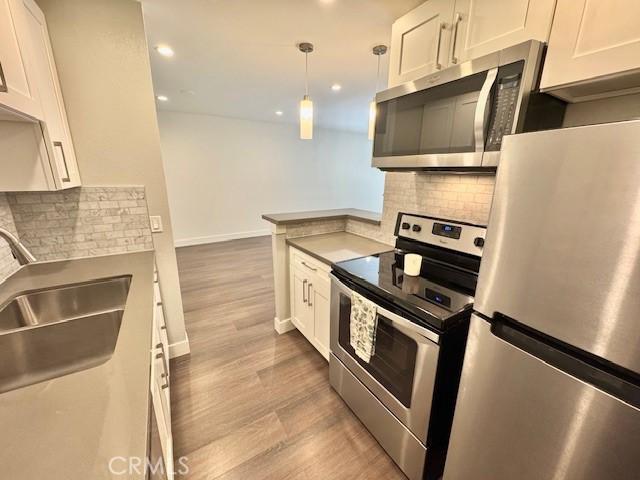 3601 W Hidden Ln Unit 309, Rolling Hills Estates, CA 90274 - kitchen with appliances with stainless steel finishes, white cabinetry, tasteful backsplash, and recessed lighting