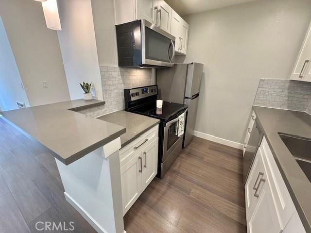 3601 W Hidden Ln Unit 309, Rolling Hills Estates, CA 90274 - kitchen featuring appliances with stainless steel finishes, backsplash, dark wood-style flooring, and white cabinetry