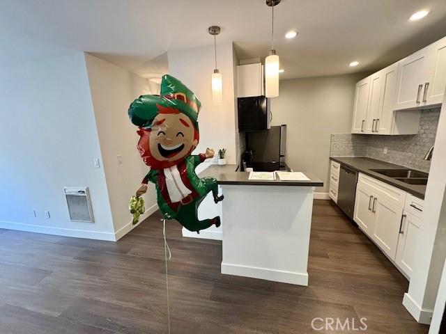 3601 W Hidden Ln Unit 309, Rolling Hills Estates, CA 90274 - kitchen with appliances with stainless steel finishes, dark countertops, dark wood-type flooring, baseboards, and a sink