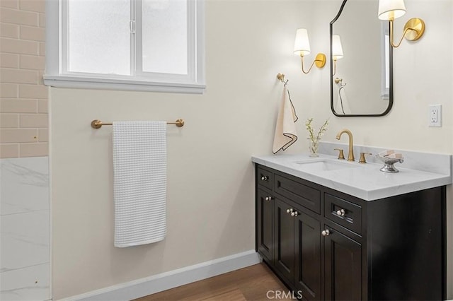 bathroom featuring baseboards, wood finished floors, and vanity