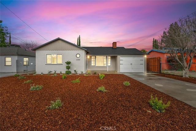 ranch-style house with a chimney, stucco siding, an attached garage, fence, and driveway