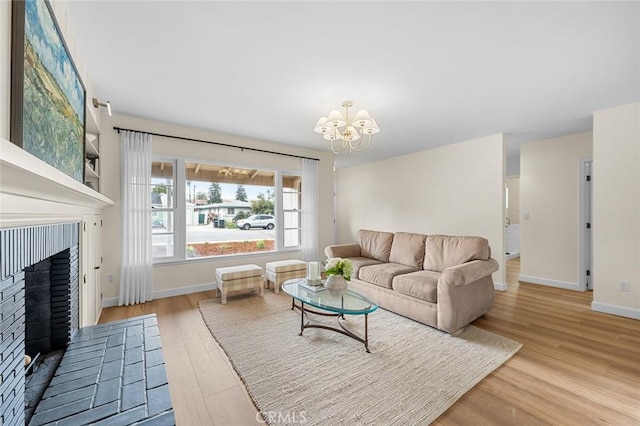 living area with a notable chandelier, a fireplace, baseboards, and wood finished floors