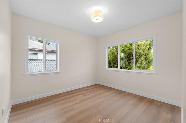 empty room featuring baseboards and light wood-style floors