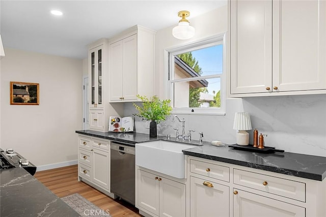 kitchen with dishwasher, light wood-type flooring, a sink, and white cabinetry