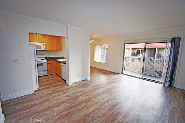 kitchen with white appliances, crown molding, open floor plan, and light wood-style floors