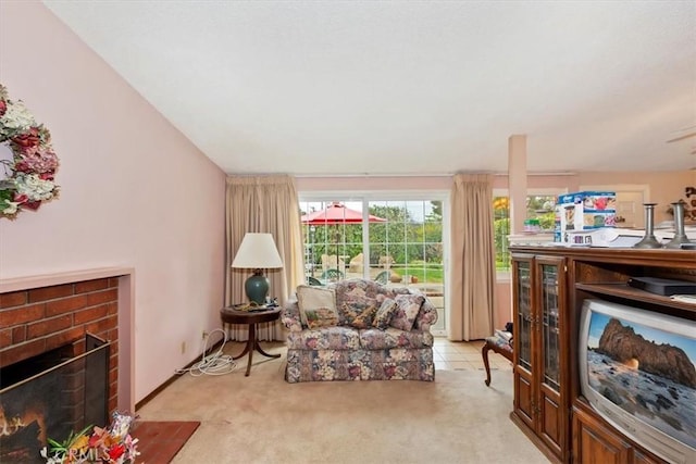 living area with light carpet and a brick fireplace