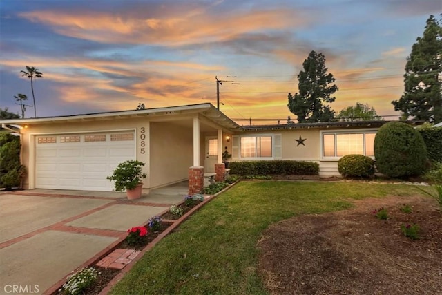 ranch-style home with stucco siding, a front lawn, a garage, and driveway