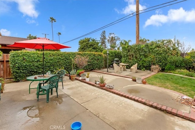 view of patio featuring outdoor dining space and fence