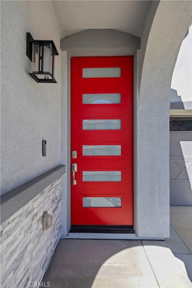 doorway to property featuring stucco siding