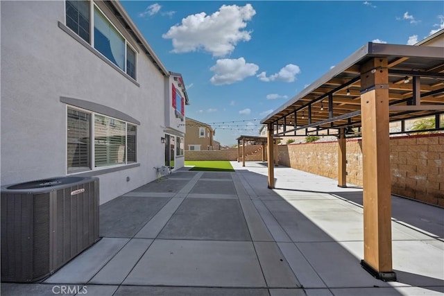 view of patio / terrace featuring central AC unit and fence