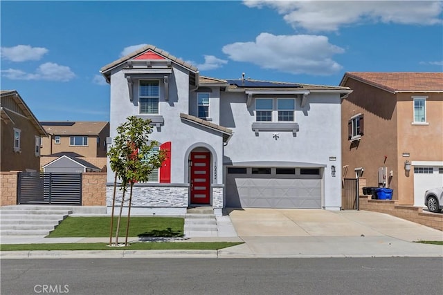 view of front facade featuring a garage, concrete driveway, a tiled roof, roof mounted solar panels, and stucco siding