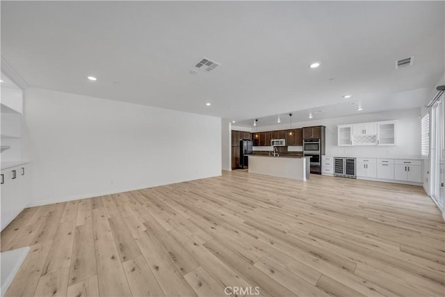 unfurnished living room with light wood-style floors, recessed lighting, visible vents, and baseboards