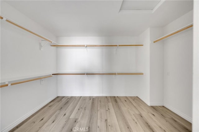 spacious closet featuring attic access and wood finished floors