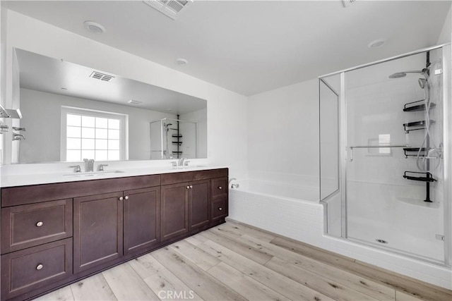 bathroom with visible vents, a sink, a shower stall, and a bath