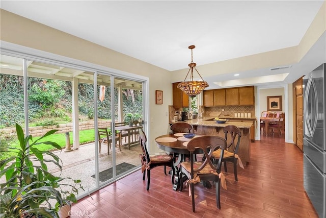 dining space featuring dark wood-style floors, a chandelier, and visible vents