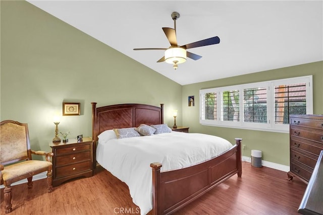 bedroom with lofted ceiling, ceiling fan, wood finished floors, and baseboards