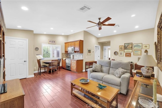 living area with a ceiling fan, recessed lighting, visible vents, and wood finished floors