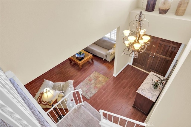 entryway featuring an inviting chandelier, a high ceiling, baseboards, and dark wood-type flooring