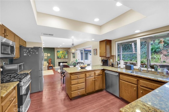 kitchen with visible vents, appliances with stainless steel finishes, a raised ceiling, and a sink