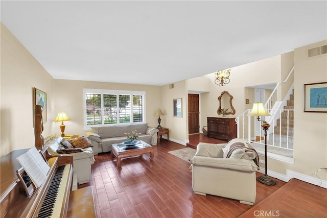 living room featuring visible vents, stairway, baseboards, and wood finished floors