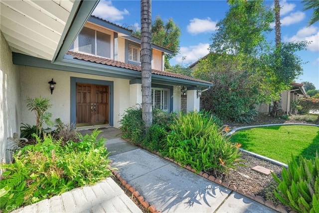 property entrance with a tile roof and stucco siding