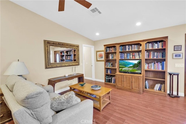 living area featuring lofted ceiling, light wood-style flooring, visible vents, and recessed lighting