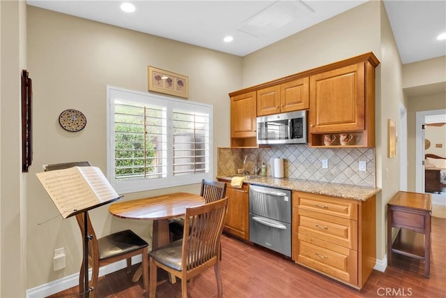 kitchen with stainless steel microwave, wood finished floors, and decorative backsplash