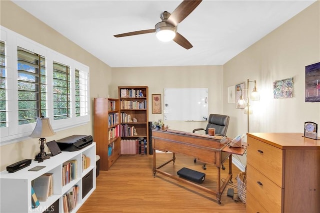 home office featuring light wood-style floors, radiator heating unit, and a ceiling fan