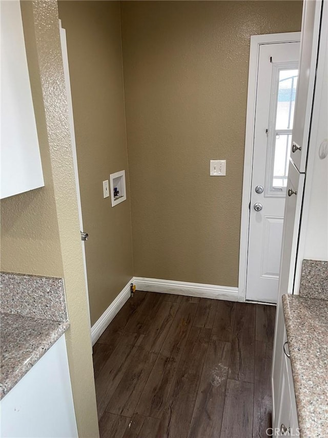 laundry area with dark wood-type flooring, washer hookup, a textured wall, and baseboards