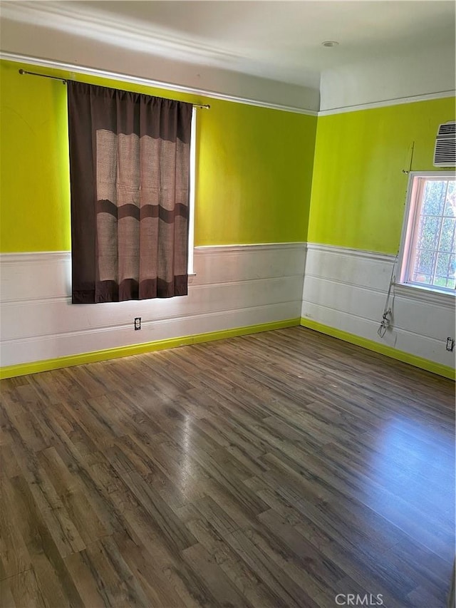 spare room with a wainscoted wall and wood finished floors