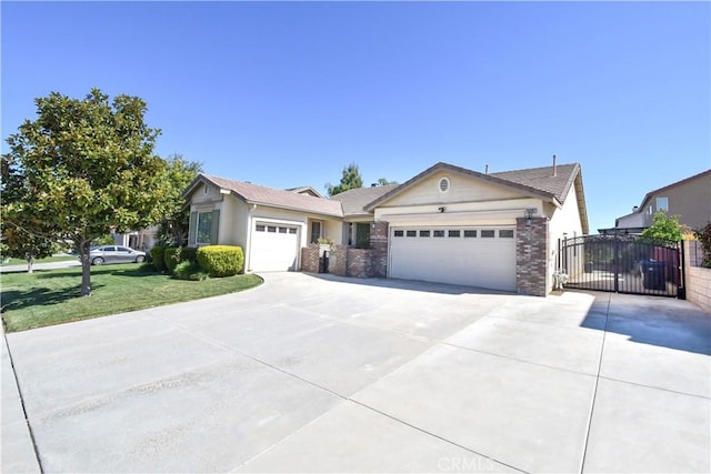 ranch-style home with brick siding, an attached garage, concrete driveway, and a gate