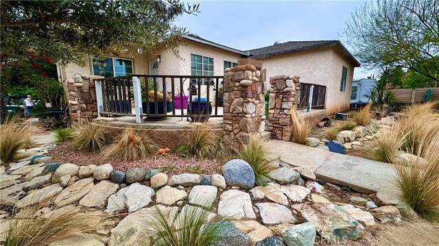 rear view of house featuring stucco siding