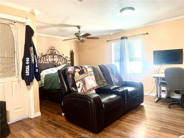 bedroom featuring wood finished floors, a textured ceiling, ceiling fan, and crown molding