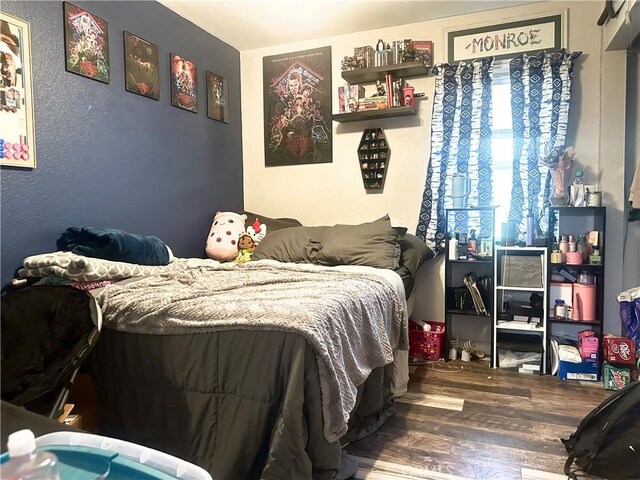 bedroom featuring a textured wall and wood finished floors